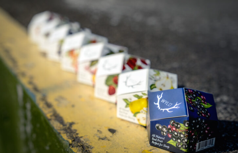 wyld gummies of different fruits lined up in a row on a wooden surface
