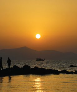 2 individuals relaxing and enjoying the sunset after having WYLD Peach Gummies
