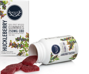 wyld huckleberry cannabis gummies spilled out of a white wyld huckleberry thc gummies container with the carton by the side